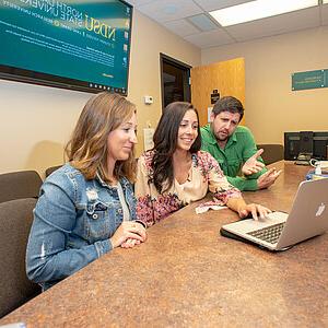 image of students around laptop in conference room
